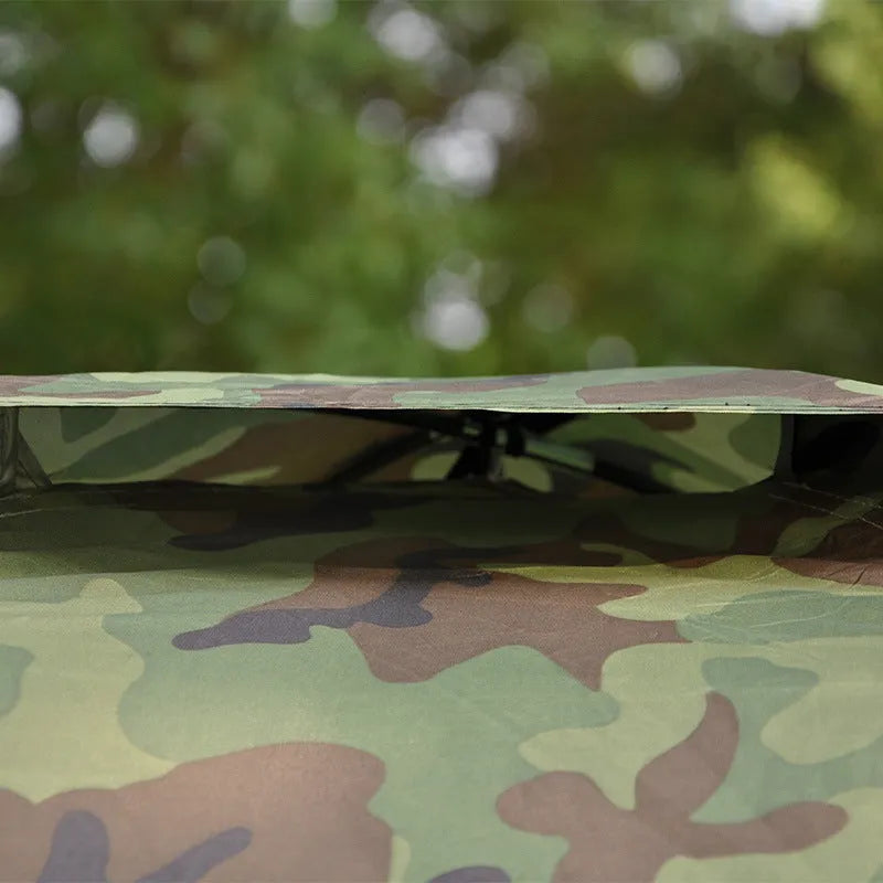 Green camouflage two-person tent with mesh windows and triangular skylight, shown erected outdoors.