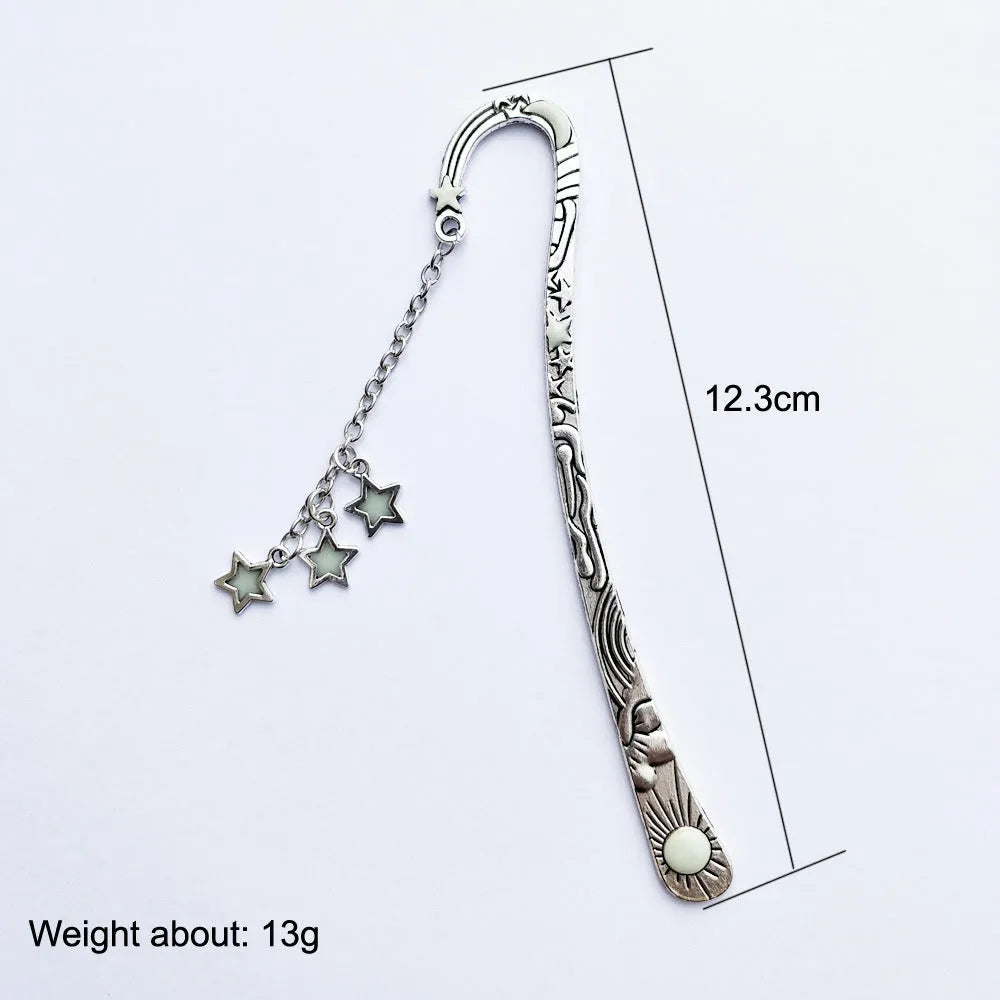 Metal bookmark with glowing five-pointed star and celestial sun moon stars design