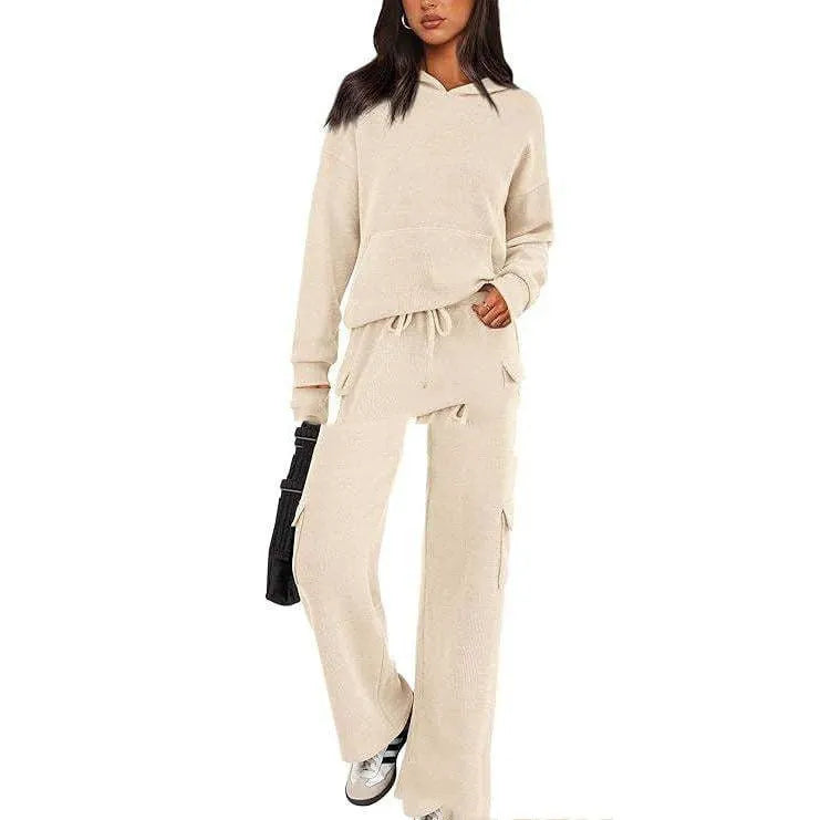 Women's black and grey spliced design polyester sports suit with long sleeves and full-length trousers laid flat.