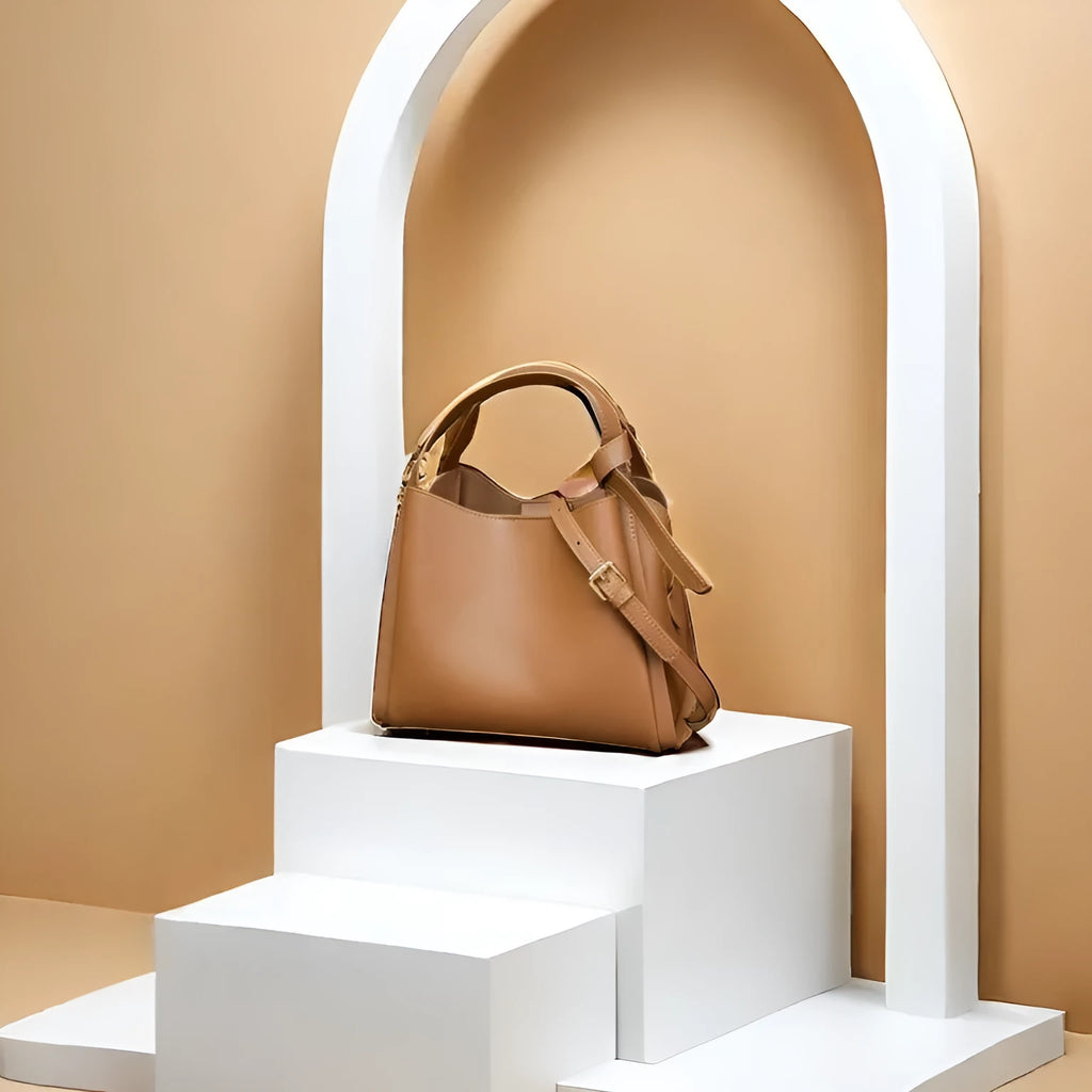 Brown cowhide leather women's bucket crossbody bag with visible stitching and a crossbody strap.