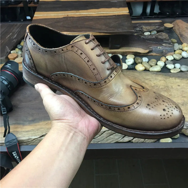 Light brown men's distressed leather lace-up shoes with engraved detailing and round toe on a neutral background.