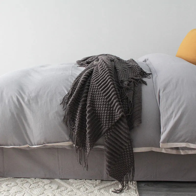 Small light grey polyester nap blanket folded, showing its texture and size.