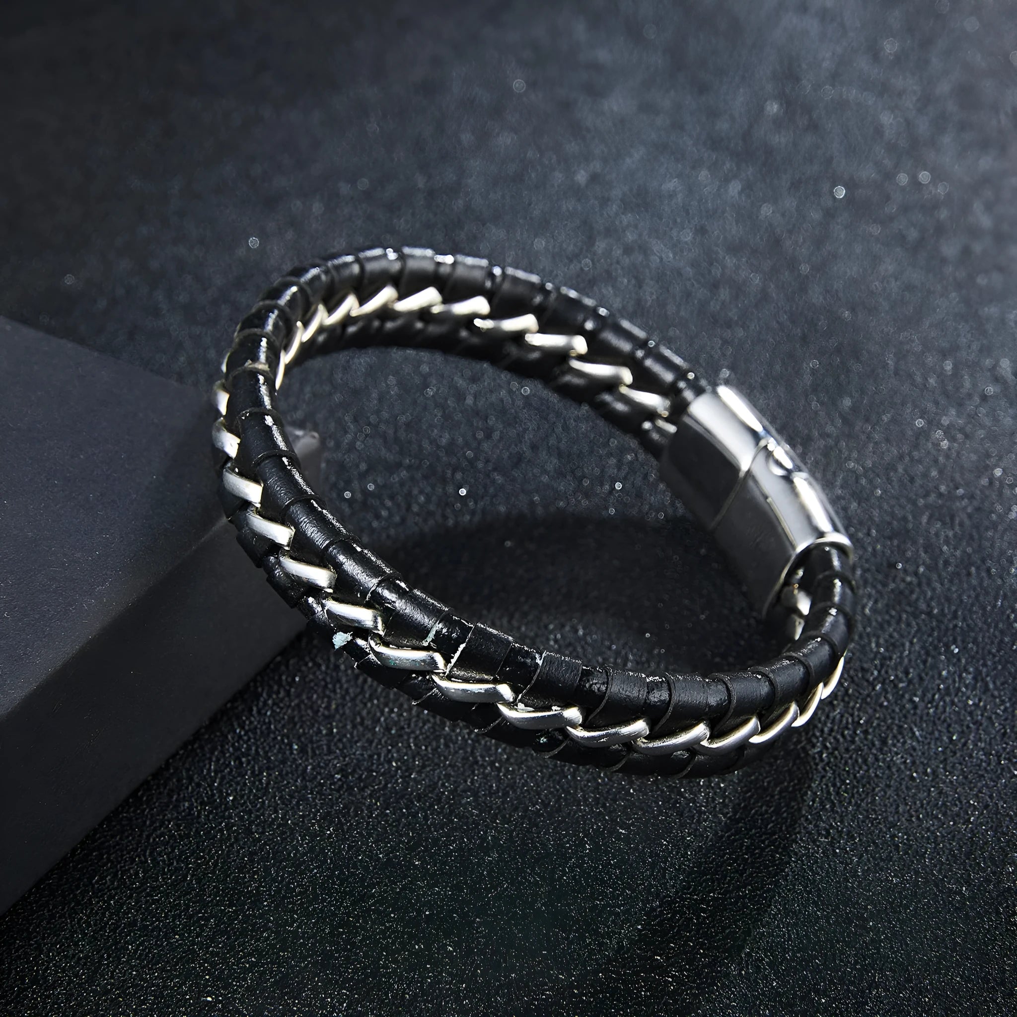 Woven leather bracelet for men with silver alloy cuff on a neutral background