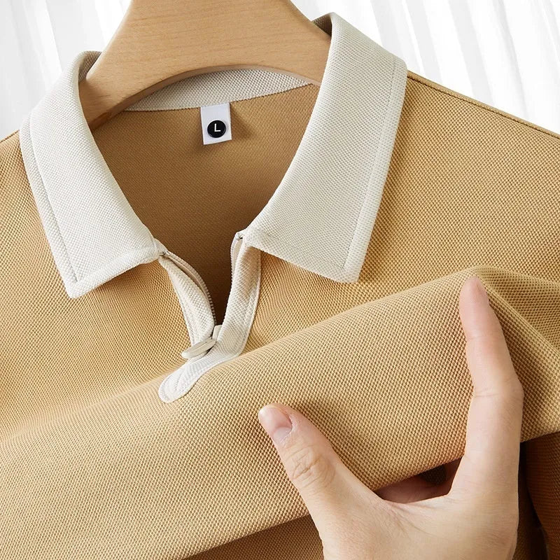 Man's solid colour polo shirt with a front zipper and lapel collar, shown in a loose fit.