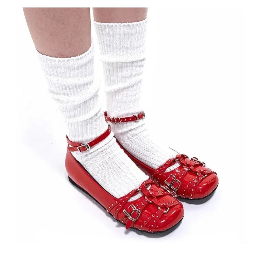 Black women's patent leather buckle pumps with a square toe and flat rubber sole.