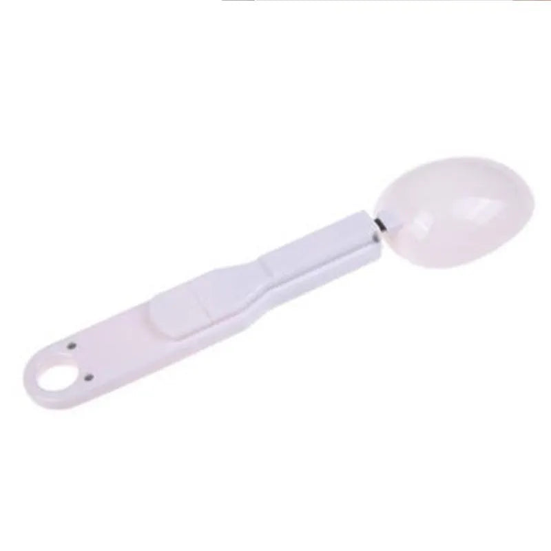 White digital spoon kitchen scale with LCD display showing weight measurement.