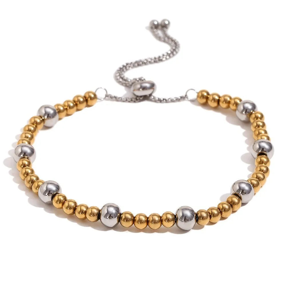 Gold geometric earrings, bracelet, and necklace set on a plain background