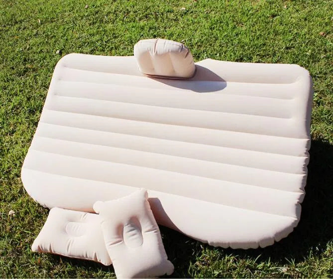 Inflatable car bed with flocked surface and pillows, set up in the back of a five-seater vehicle.