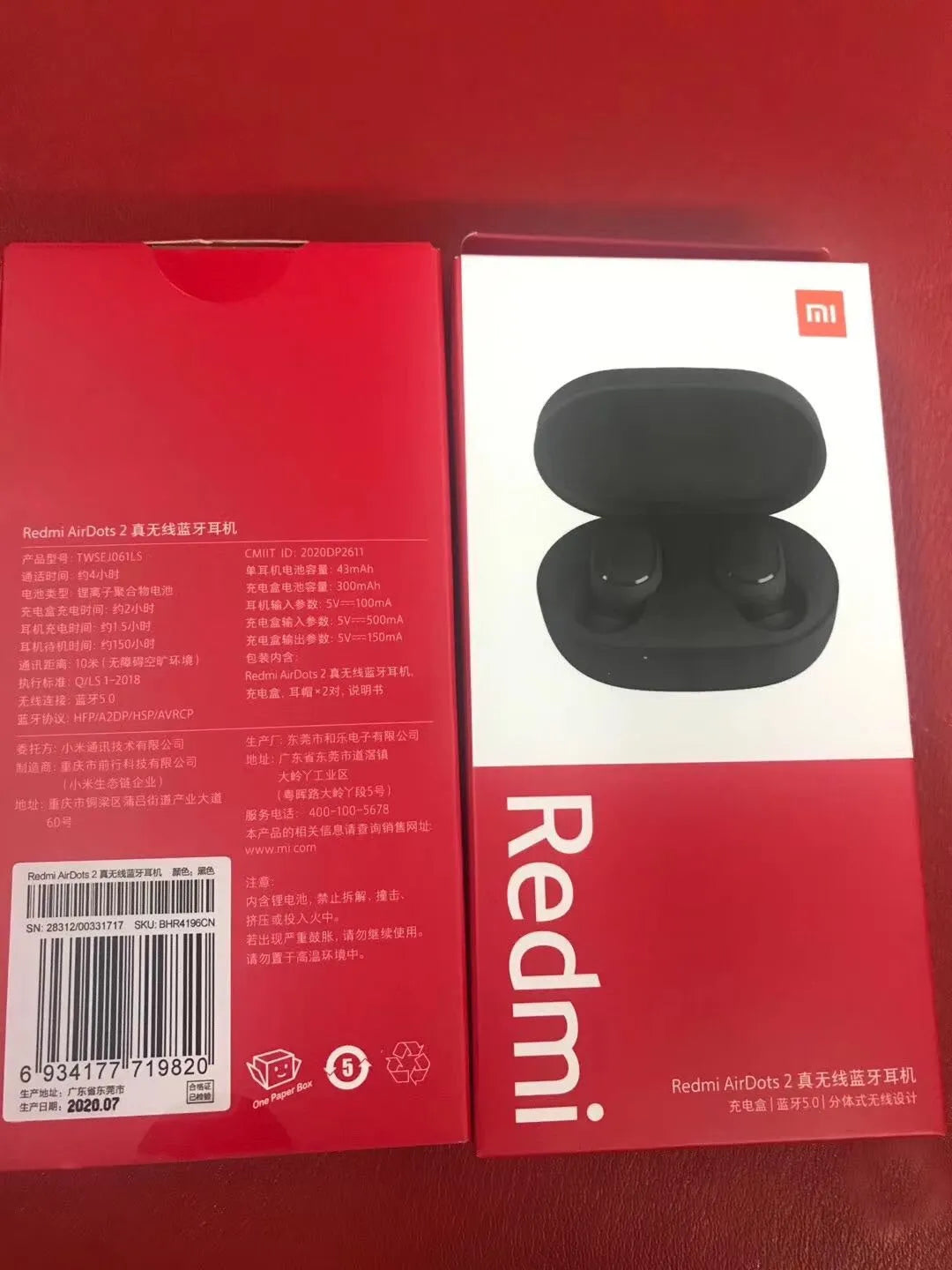 Black Redmi AirDots true wireless earbuds next to their compact charging case.