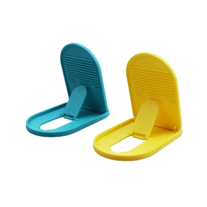 Plastic lazy bracket mobile phone stand in multiple colour choices on a table.