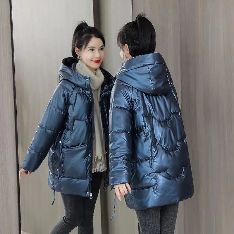 Green loose-fit women's hooded winter jacket with long sleeves on a hanger