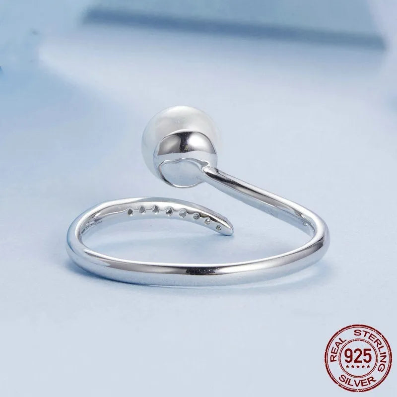 Adjustable open-loop sterling silver ring featuring a genuine shell pearl.