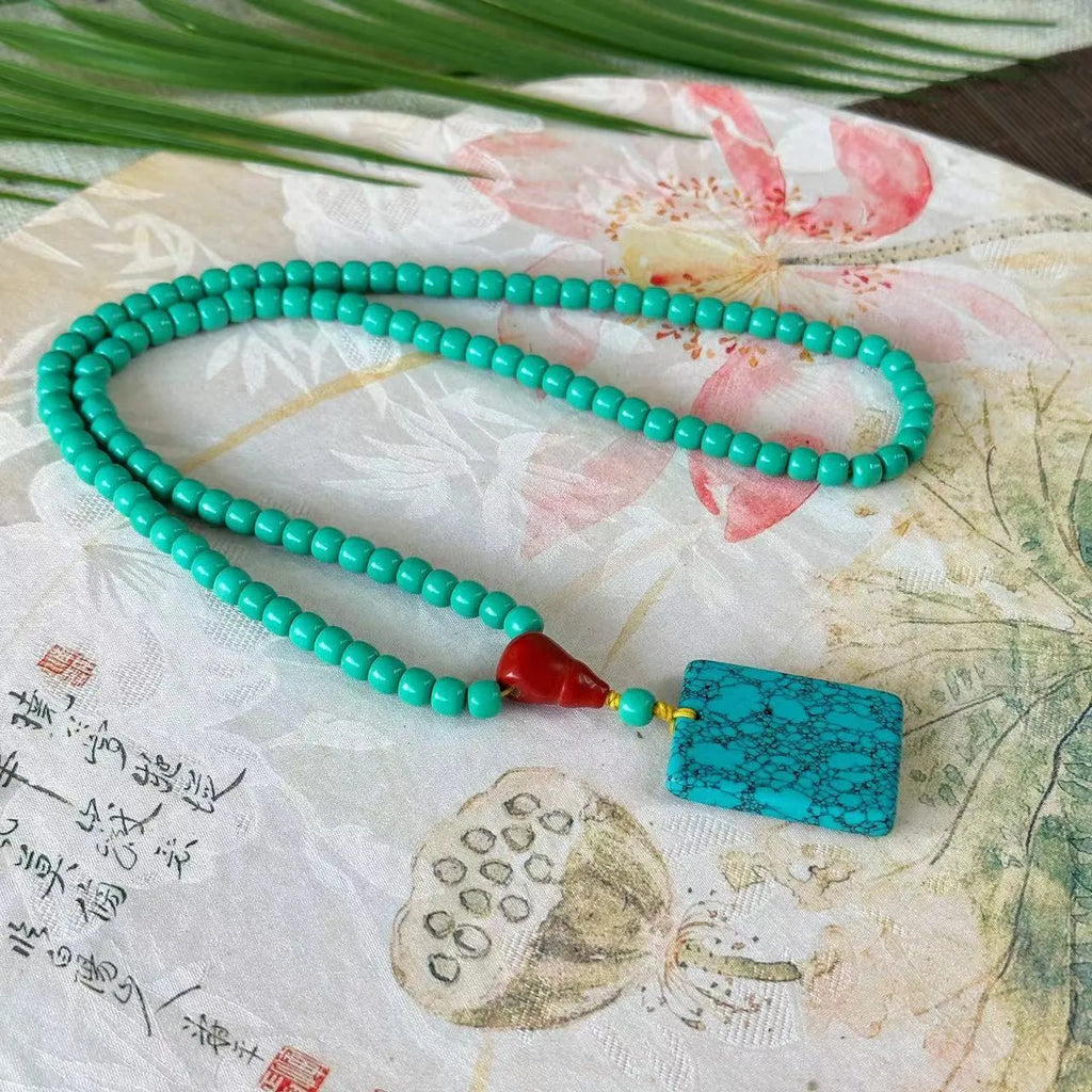 Turquoise stone mesh flower pendant on an adjustable ball bead necklace chain.