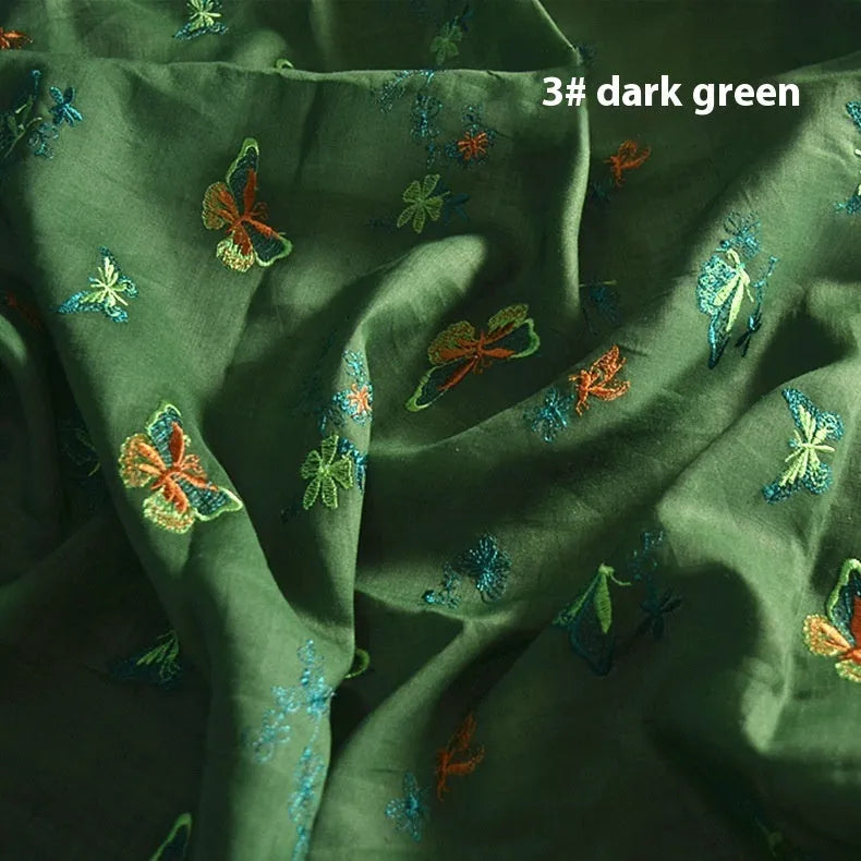 A piece of pure ramie embroidery fabric in a grass green colour, showing its woven texture.