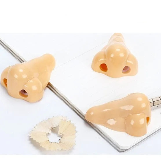 Flesh-coloured plastic manual pencil sharpener with a geometry shape, shown next to a pencil for scale.