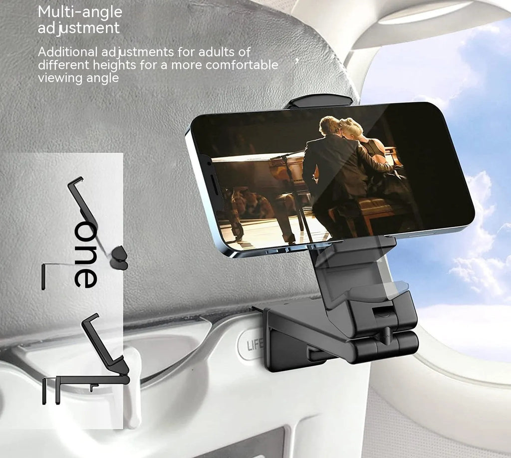 A black foldable rotating lazy phone holder gripping a mobile smartphone on a desk.