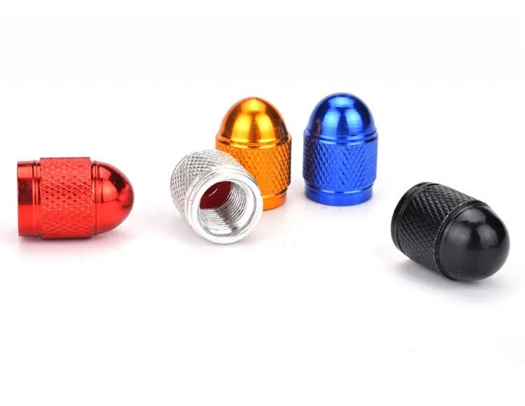 Aluminium alloy bicycle tyre valve cap in assorted colours on a black background.