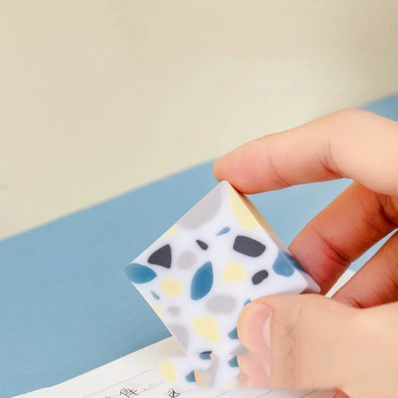 A white brick-shaped soft rubber eraser for traceless pencil correction.