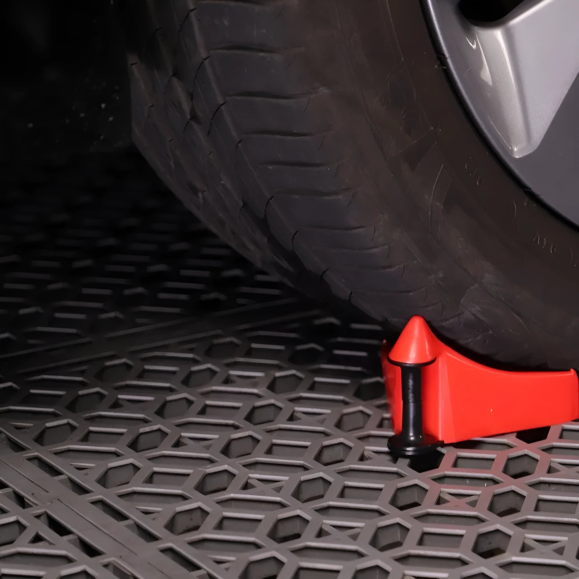 Set of four bright red, wedge-shaped rubber parking blocks for car tyres.