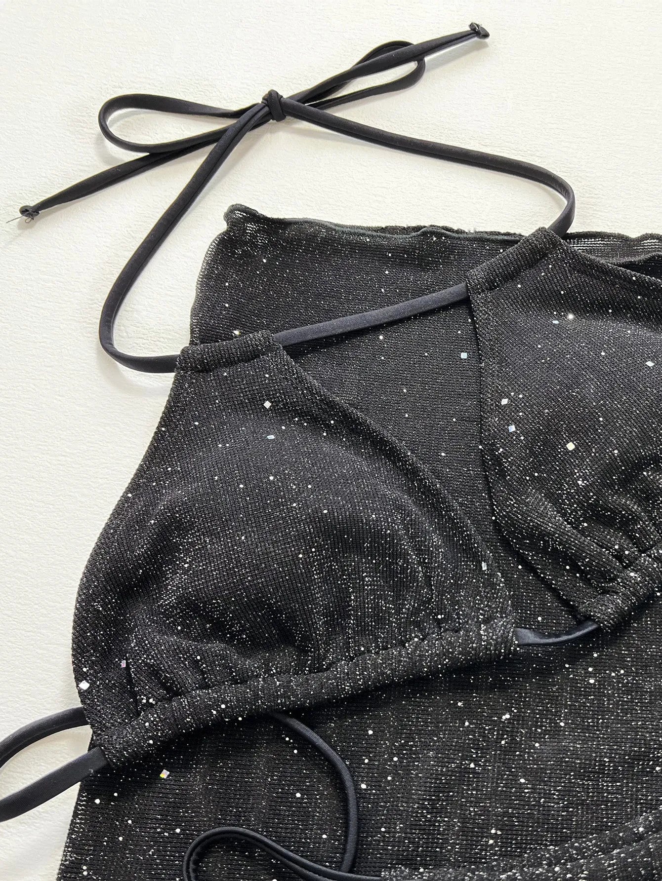 Black women's three-piece bikini set with separate top and shorts on a mannequin.