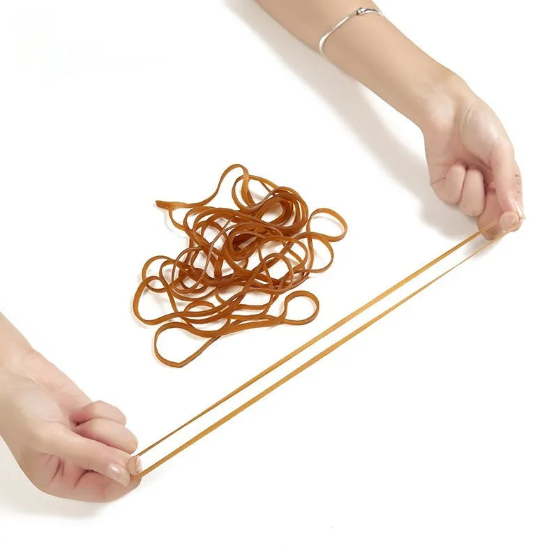 A bag containing numerous natural-coloured circular rubber elastic bands, total weight 500 grams.