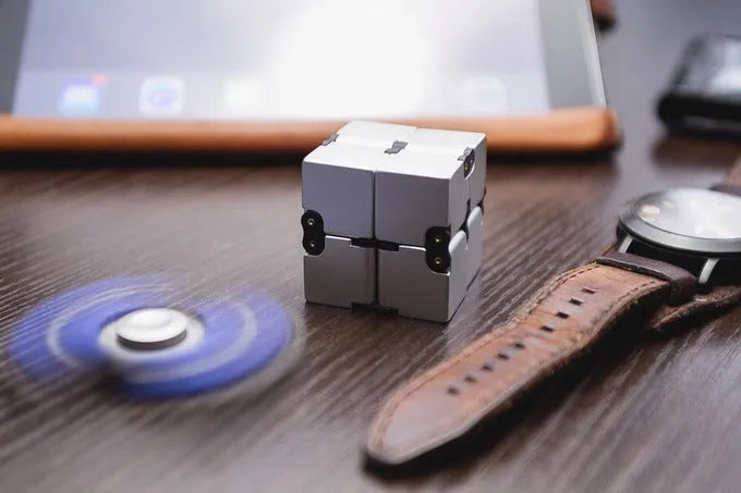 Black zinc alloy infinity cube fidget toy showing rotated cubes, on a white background.
