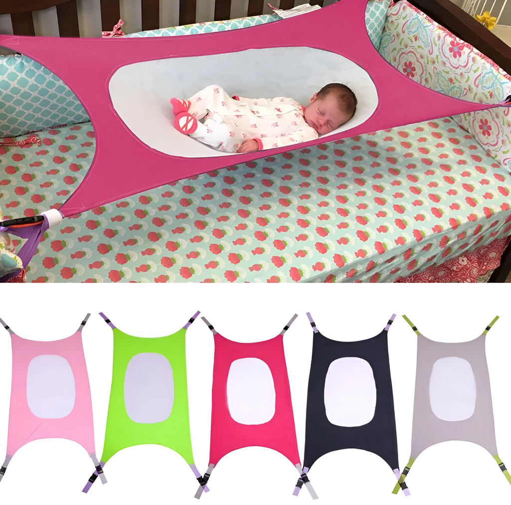 Portable crushed velour baby hammock attached to a white crib, shown in a pink colour.
