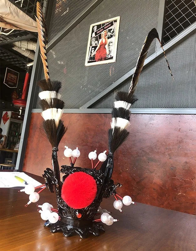 Black crown and long feather decoration for customising a motorcycle helmet.