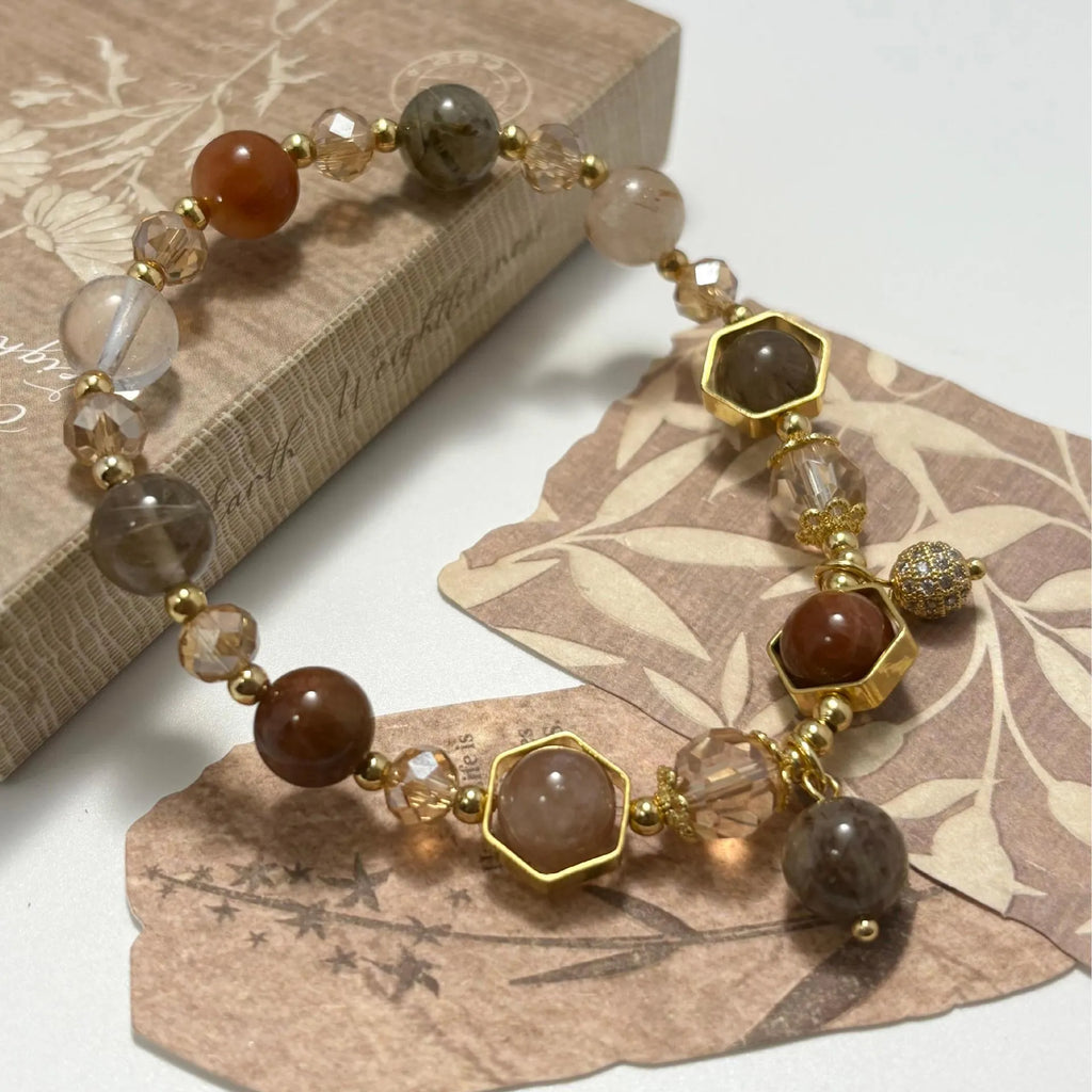 Gold citrine crystal bracelet with Fu character, safety lock, and cloud pattern charms on wrist