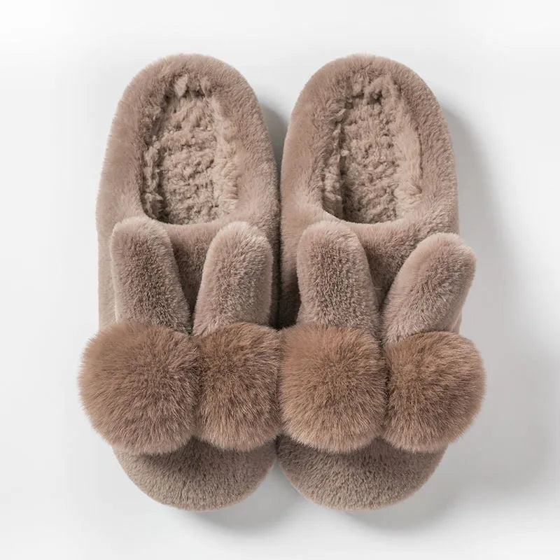 Women's fluffy rabbit fur slippers in pink, shown as slip-on winter shoes.