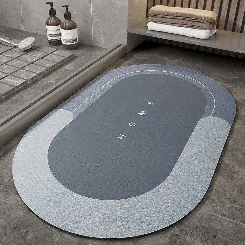 Machine woven bathroom floor mat in blue colour, shown in an oval shape on a tiled floor.