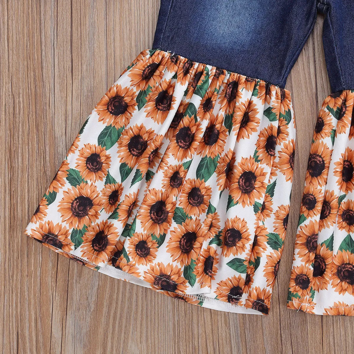 White kids two-piece cotton outfit with short sleeve top and trousers featuring denim torch and sunflower print