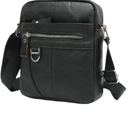 Retro brown leather messenger bag with crossbody strap on a table.