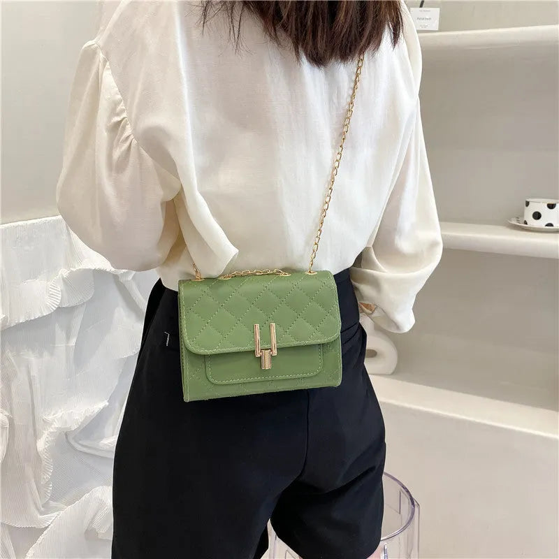 Women's white diamond lattice chain crossbody bag showing adjustable strap and structured shape