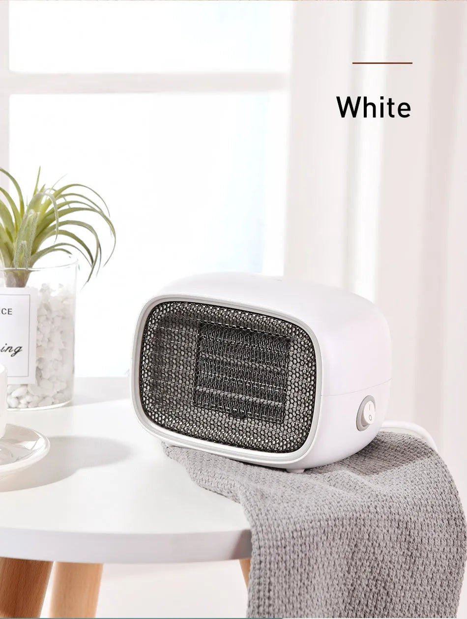 Compact green mini ceramic heater on a desktop showing its small size and EU plug.