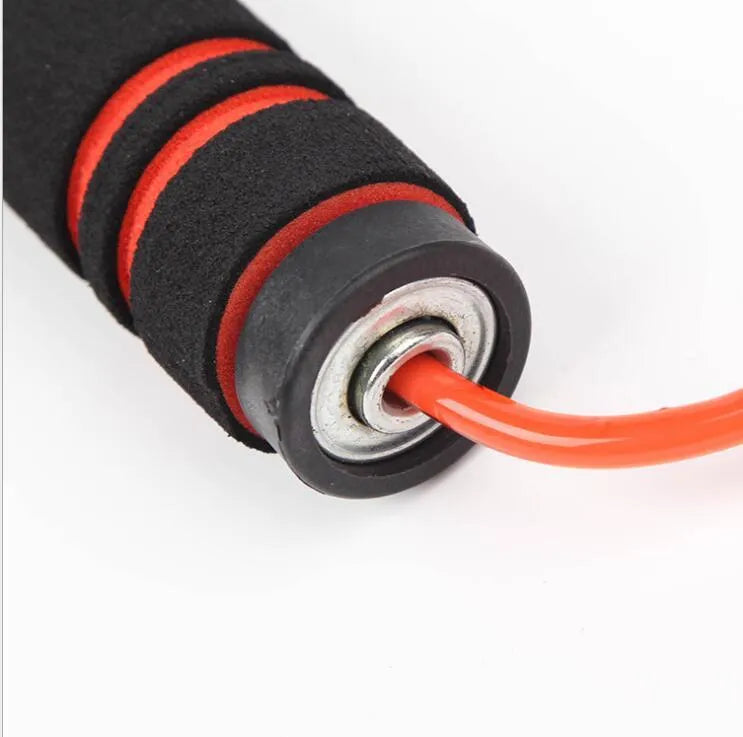 Adjustable jump rope with weighted black handles on a gym mat