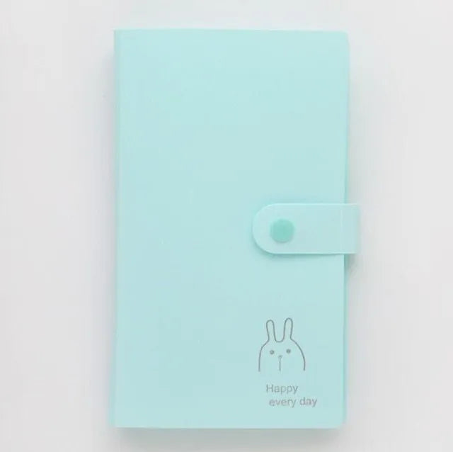 Blue PVC business card holder book with a protective shell and smile logo, shown next to business cards.