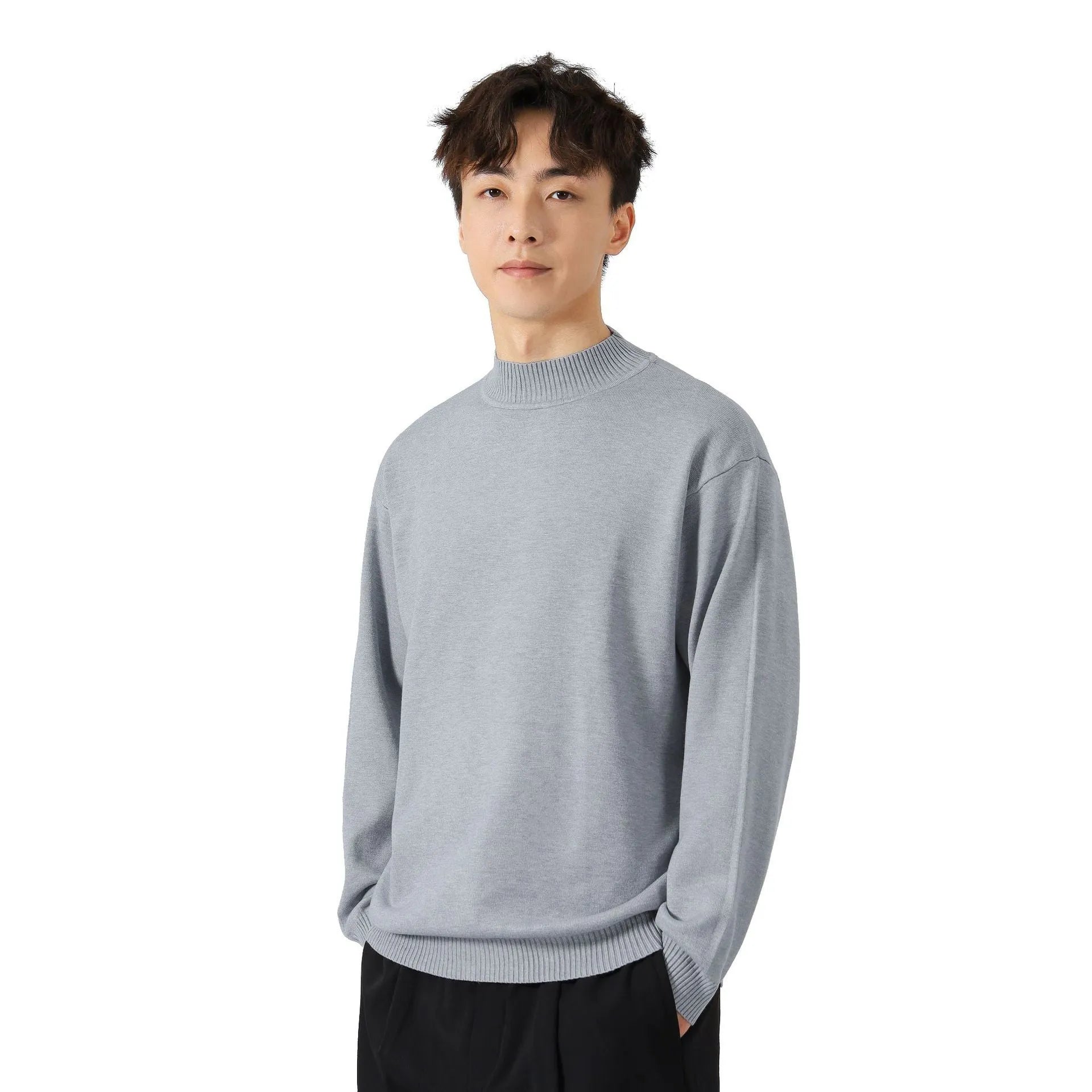 Man wearing a loose-fit long-sleeve solid colour sweater in a casual setting.