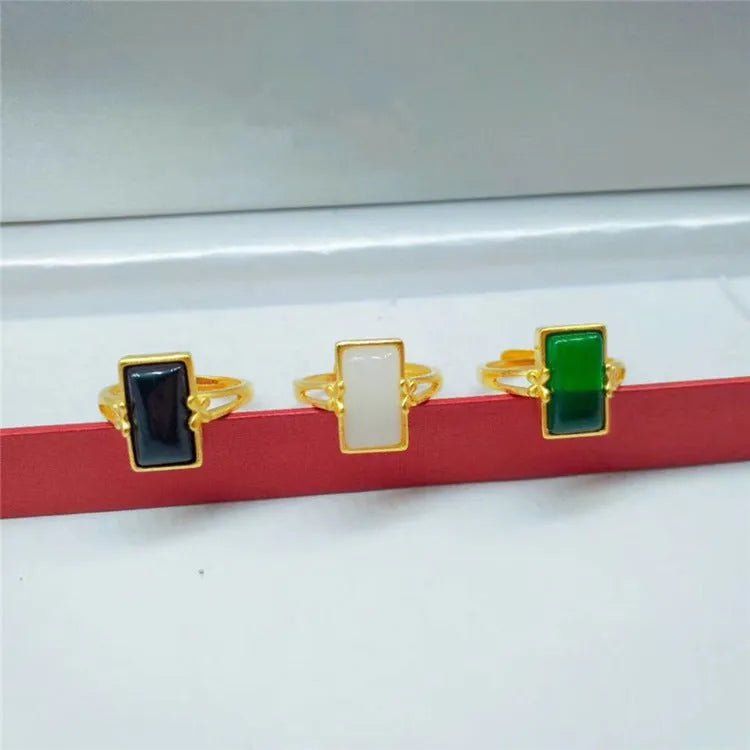 Adjustable brass gold-plated ring with a green gemstone inlay, showing national style design