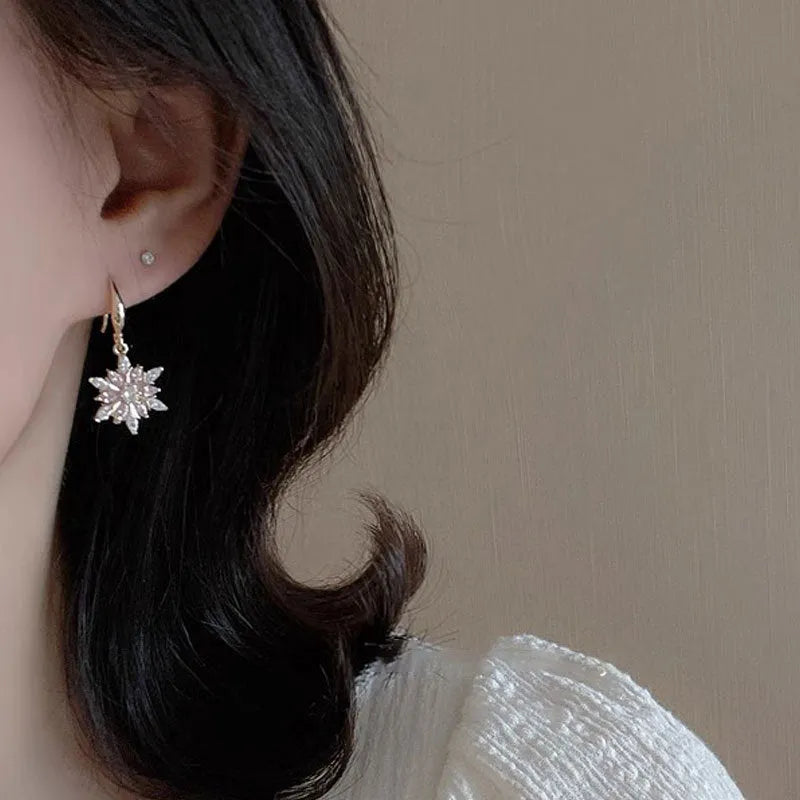 Gold alloy snowflake earrings with central zircon stone for women
