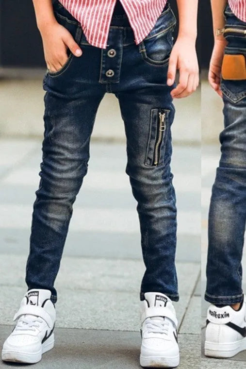 Boy wearing dark blue stretch denim jeans with zipper pockets, size chart shown