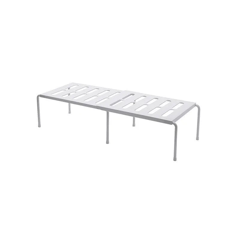 White telescopic plastic kitchen rack with single shelf, shown at adjusted height on a kitchen floor.