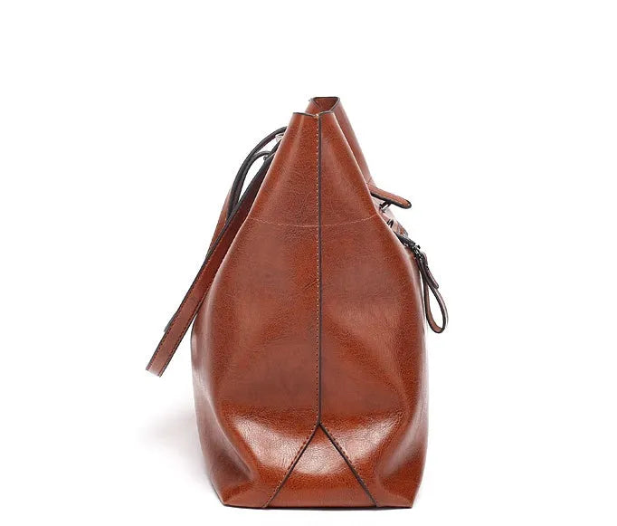 Brown waxed cowhide cross-body handbag with zip, showing two compartments and adjustable strap.