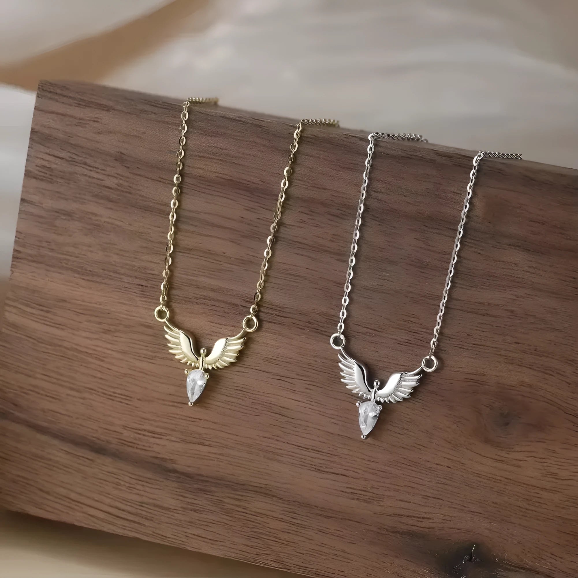 Close-up of a women's adjustable silver necklace with an eagle pendant on an O-ring chain, showing white gold and yellow gold colour options.