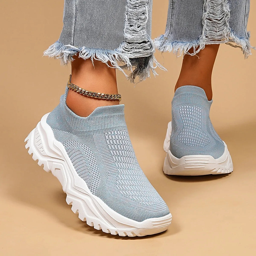 Women's light blue mesh slip-on sports shoes with a rounded toe and mid heel.