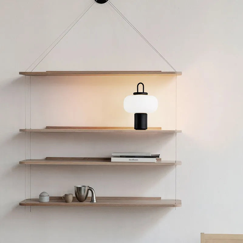Minimalist Japanese glass bedside table lamp with warm light for a child's bedroom.