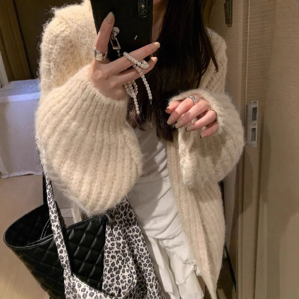 A woman's loose-fitting, hooded sweater cardigan in a solid colour, shown with regular sleeves.
