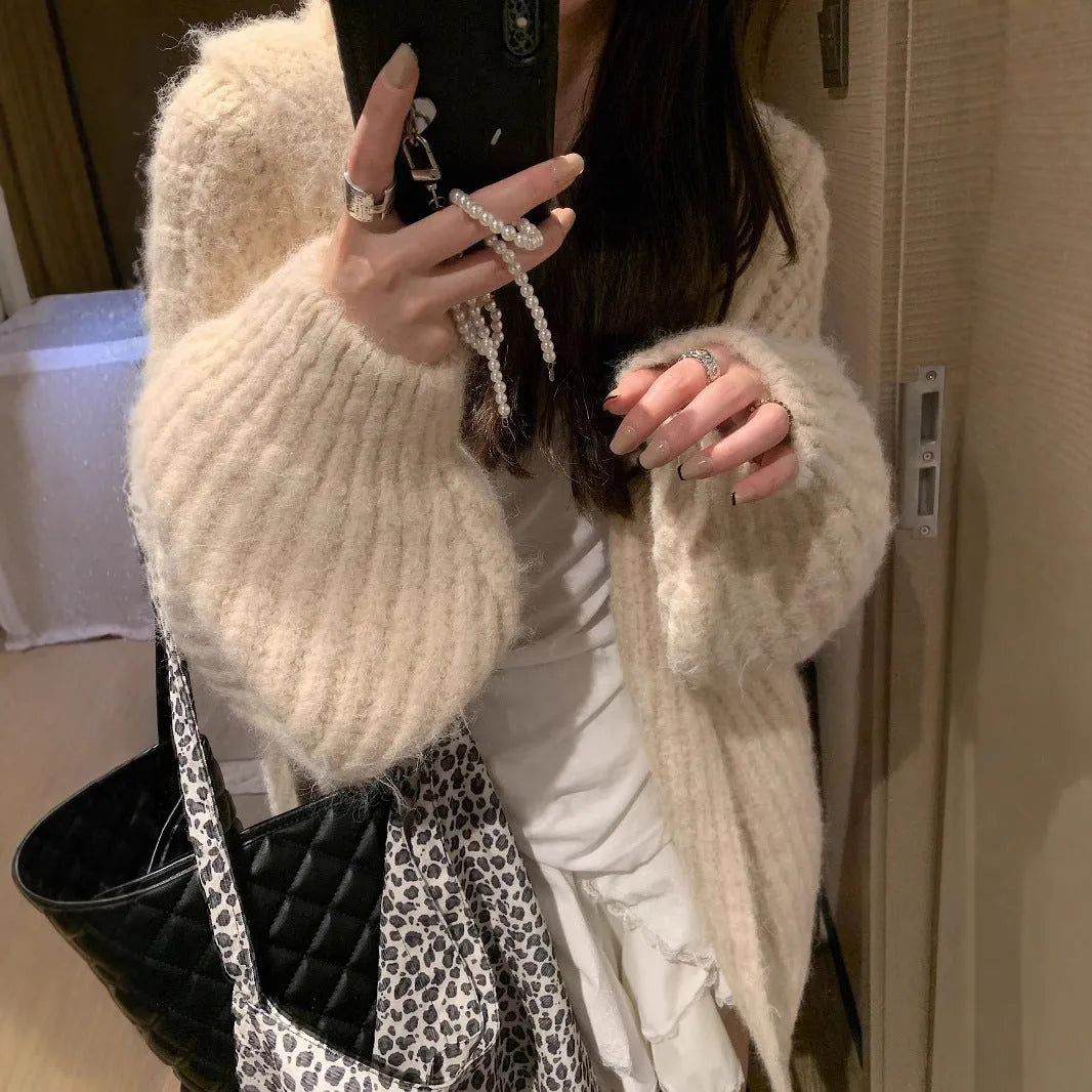 A woman's loose-fitting, hooded sweater cardigan in a solid colour, shown with regular sleeves.