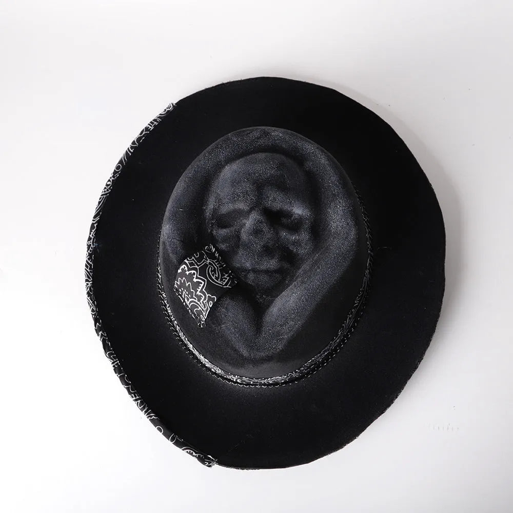 Handmade wool felt conical crown skull hat for Halloween costumes on a dark background.