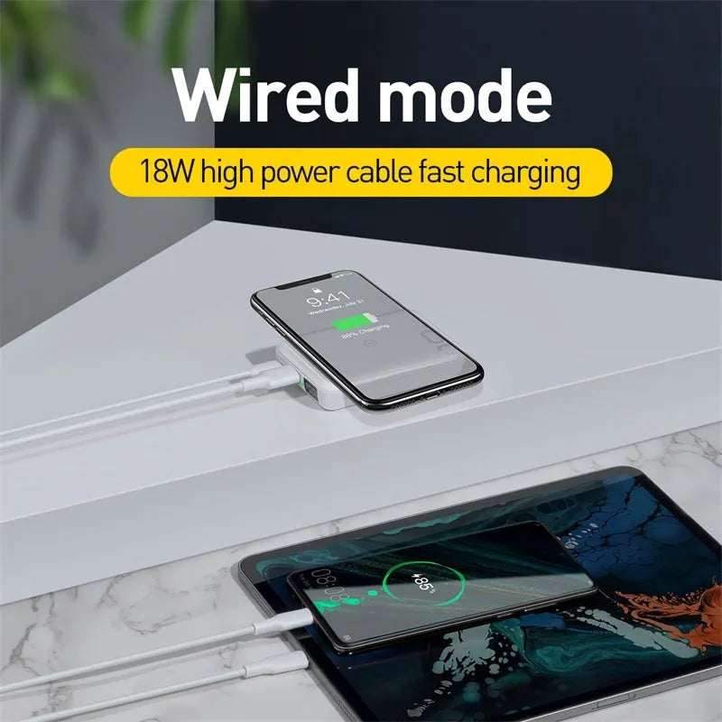 Small square black portable power bank with wireless charging surface and digital LED display.